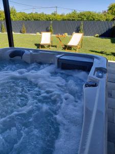 a hot tub filled with water with two chairs at Kuća za odmor PAVIĆ in Vinkovci