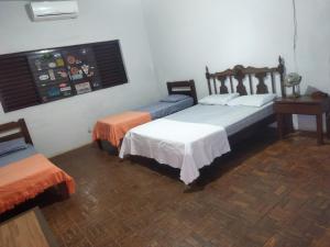 a room with two beds and a table and a window at Cantinho da Flor in Barretos +10 photos