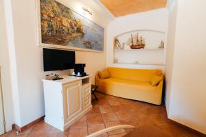 a living room with a yellow couch and a tv at CETARA - ALBERGO DIFFUSO in Cetara