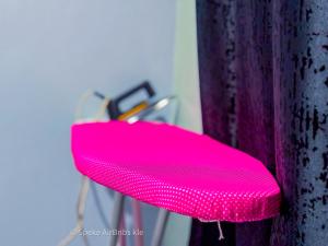 a bright pink chair sitting next to a wall at Speke homes full apartment!!! in Kabale