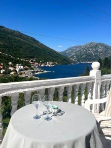 a table with two wine glasses on a balcony at Open Sky Verige Studio in Donja Jošica
