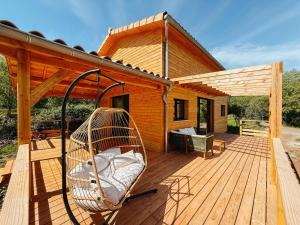a wooden deck with a swing on a house at Le Chalet de la Boussonie in Les Vans