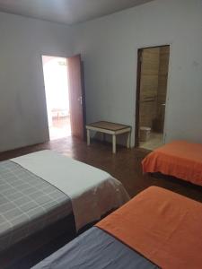 a room with two beds and a table in it at Cantinho da Flor in Barretos