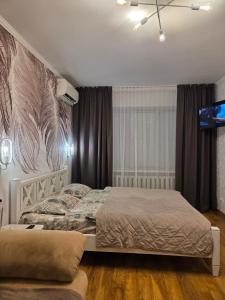 a bedroom with two beds and a flat screen tv at Апартаменты в центре in Chernihiv