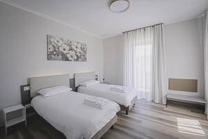 a hotel room with two beds and a television at CuorNice - LG Estate in Ripe San Ginesio