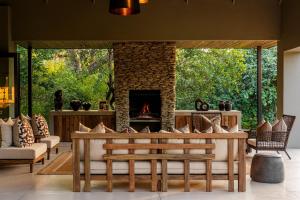 a living room with a fireplace and a couch at Ujima Lodge in Hoedspruit