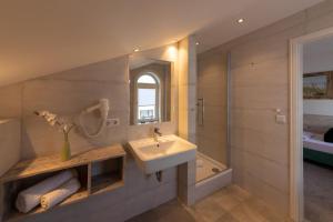 a bathroom with a sink and a mirror and a tub at Marin Hotel Sylt GmbH in Westerland +44 photos