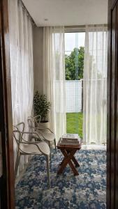 a room with two chairs and a table and a window at Chalé Arandu in Santo Amaro