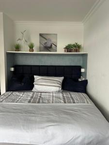 a bedroom with a large bed with a blue headboard at Modernes Apartment mit Pool und Sauna in Möhnesee +28 photos