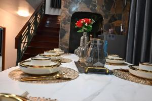 a table with plates and bowls and a vase with flowers at Patong Beach private Villa in Patong Beach