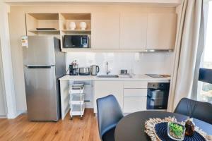 a kitchen with a refrigerator and a table and chairs at Just 100 meters from Shopping del Sol in Asunción