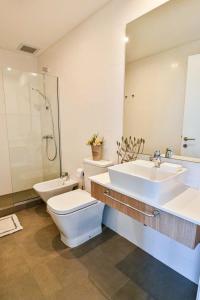 a bathroom with a sink and a toilet and a mirror at Just 100 meters from Shopping del Sol in Asunción +22 photos