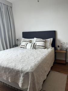 a bedroom with a bed with white sheets and pillows at Just 100 meters from Shopping del Sol in Asunción