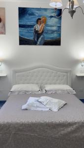 a bedroom with a bed with a picture on the wall at Il borgo di Iaconti in Vietri sul Mare