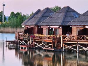 a group of wooden huts on the water at Domček na vode 5 in Senec