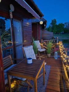 a wooden deck with a wooden table and chairs at Domček na vode 5 in Senec +15 photos