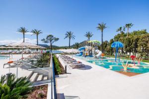 a pool with chairs and umbrellas at a resort at VIVA Eden Lago in Port d'Alcudia