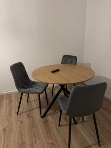 a wooden table with two chairs and a remote control on it at Mieszkanie BLOK in Złotów