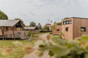 a house and a building with a yard at Tiny House in Kesteren +3 photos