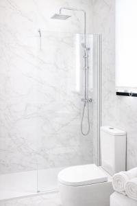 a white bathroom with a shower and a toilet at Cabañas Compostela - Cabaña Bosque Encantado in Santiago de Compostela +6 photos