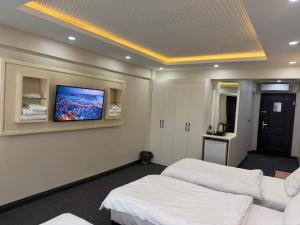 a room with two beds and a tv on the wall at lily airport otel in Arnavutköy