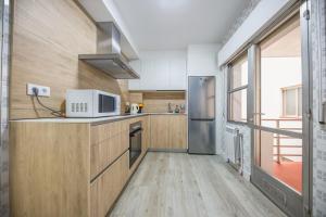 a kitchen with a refrigerator and a microwave at Villa Artista home in Pontevedra +21 photos
