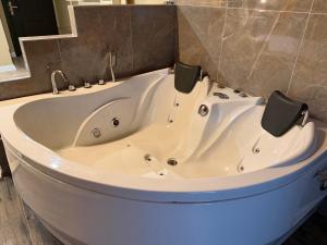 a large white bath tub in a bathroom at lily airport otel in Arnavutköy +28 photos