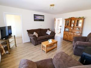 a living room with two couches and a tv at Cahir Cottage in Ballinrobe