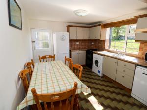 a kitchen with a table and chairs and a kitchen with a sink at Cahir Cottage in Ballinrobe