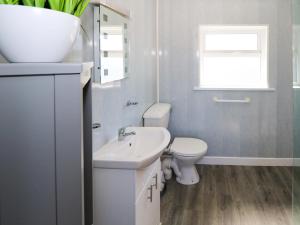 a white bathroom with a sink and a toilet at Cahir Cottage in Ballinrobe +19 photos