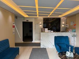 a lobby with two blue chairs and a counter at lily airport otel in Arnavutköy