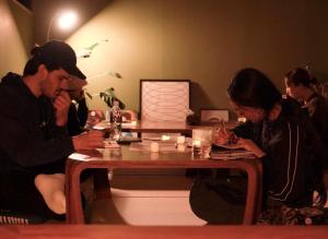 a man and a woman sitting at a table at Local Knot Backpackers in Nagano