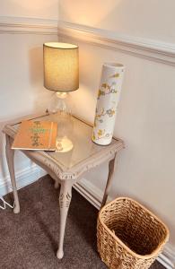 a table with a lamp and a book and a vase at Peak Retreat in Chesterfield