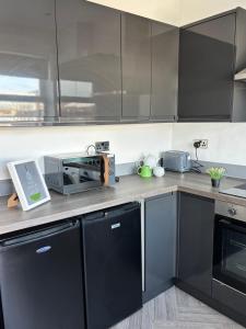 a kitchen with black cabinets and a microwave at Peak Retreat in Chesterfield