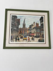 a framed painting of a city street with people at Peak Retreat in Chesterfield +15 photos
