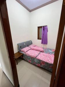 a bedroom with a bed with pink sheets at Widodaren Homestay in Probolinggo