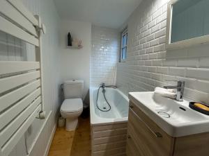 a bathroom with a toilet and a sink and a tub at Petit Cocon Intra-muros in Saint Malo