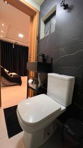 a bathroom with a white toilet and a bedroom at Sobrado inteligente, A C, TVs Smart e garagem in Toledo +59 photos