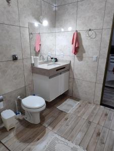 a bathroom with a toilet and a sink and a mirror at Pesqueiro Rancho dos Reis in Aquidavana