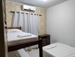 a small room with two beds and a tv at Pesqueiro Rancho dos Reis in Aquidavana