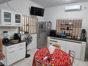 a kitchen with a table and a refrigerator at Pesqueiro Rancho dos Reis in Aquidavana