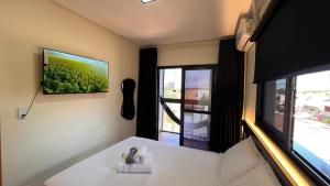 a room with a bed and a large window at Sobrado inteligente, A C, TVs Smart e garagem in Toledo