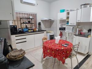 a kitchen with a table with a red table cloth on it at Pesqueiro Rancho dos Reis in Aquidavana +15 photos