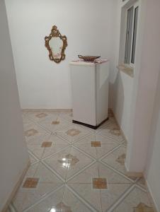 a small refrigerator in a room with a tiled floor at Maison centre in Tazarka