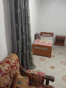 a room with a couch and a bed and a chair at Maison centre in Tazarka