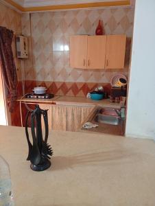 a small kitchen with a counter and a table at Maison centre in Tazarka