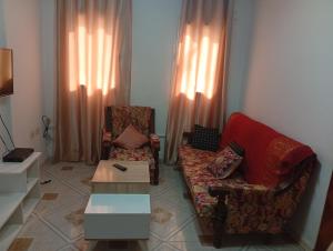 a living room with a couch and a chair at Maison centre in Tazarka