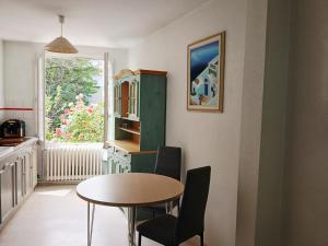 a dining room with a table and chairs and a window at Maison Angers bord de loire, rue Jules Quelin in Les Ponts-de-Cé
