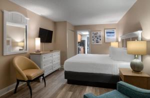 a bedroom with a bed and a desk and a chair at Landmark Resort in Myrtle Beach +60 photos