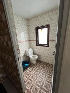 a bathroom with a toilet and a window at Widodaren Homestay in Probolinggo